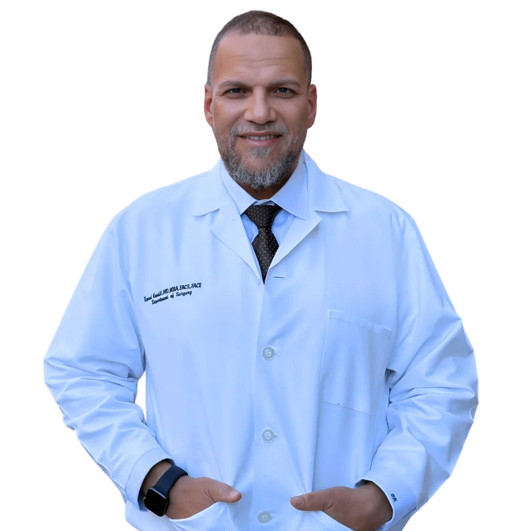 Emad Kandil, MD in light blue lab coat with embroidered credentials, smiling at camera
